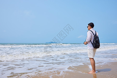 年轻男士海边旅游拍照图片