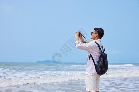 年轻男士海边旅游拍照图片