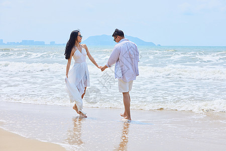 夏日海边情侣牵手散步背景