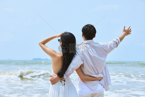 年轻情侣拥抱大海背影图片