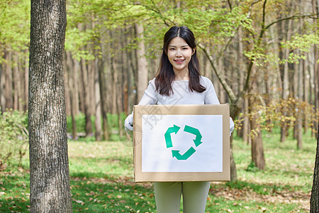 女性抱着纸箱回收垃圾图片