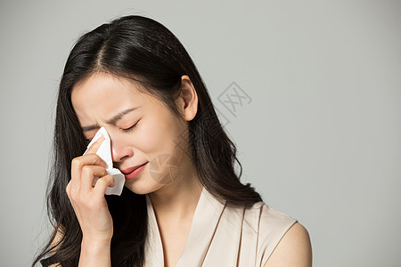 伤心的女性用纸巾擦眼泪高清图片