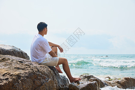 年轻男士面向大海思考图片