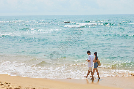 年轻情侣海边旅行背影高清图片