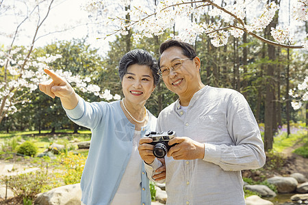 老年养生踏青的老年夫妇公园拍照背景