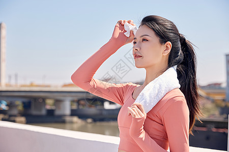 女性健身跑步用毛巾擦汗高清图片