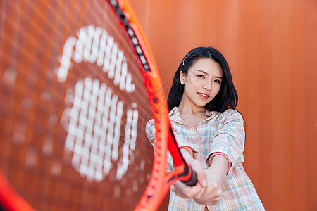 街头嘻哈时尚美女挥动网球拍背景