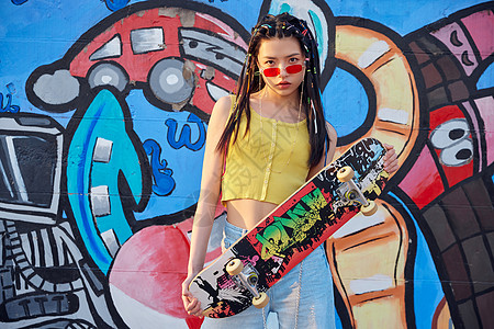 街头滑板时尚美女涂鸦墙边玩滑板背景