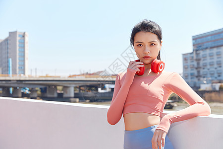 戴耳机跑步青年女性跑步运动戴耳机休息背景