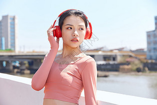 青年女性跑步运动戴耳机休息图片