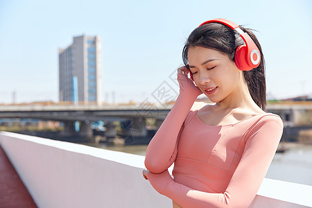 青年女性跑步运动戴耳机休息背景图片