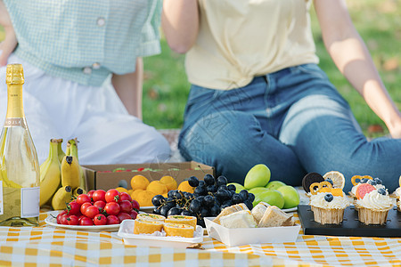 快乐的人野餐布上摆放的食物水果背景