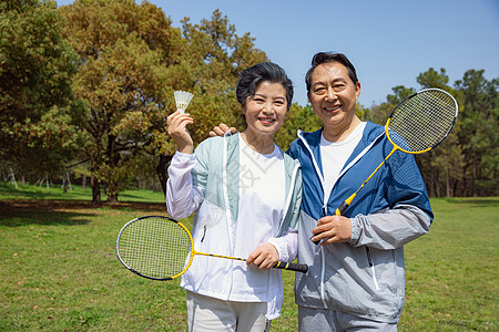 公园锻炼老年夫妇在公园打羽毛球背景
