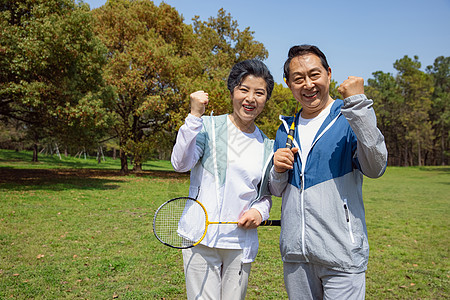 老年夫妇在公园打羽毛球高清图片