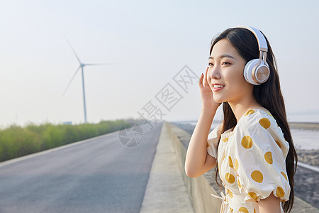 人带耳机素材在马路边带耳机听歌的悠闲少女背景