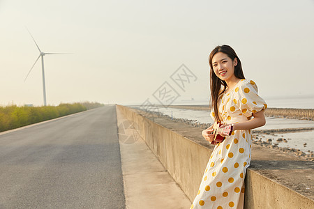 在马路边抱着尤克里里的悠闲女性图片