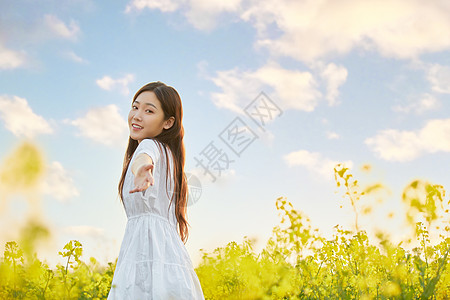 在油菜花田散步的年轻女性图片