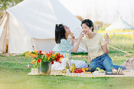 青海美女野营坐在野餐布上玩闹的闺蜜背景