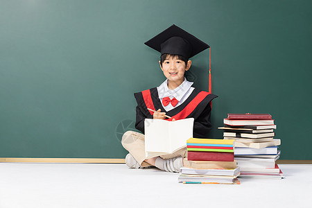 学士服男孩黑板前写作业高清图片