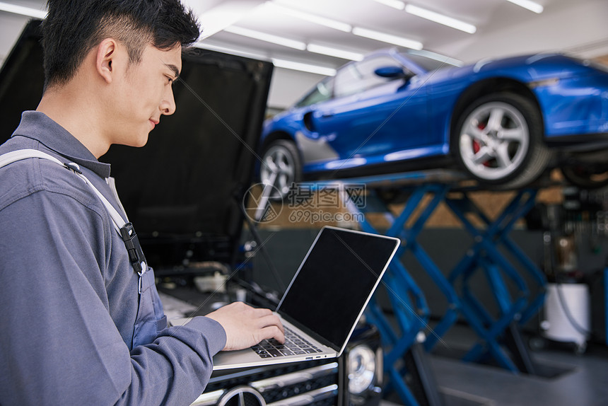 照片 职业形象 汽车修理工人使用智能设备检测汽车.