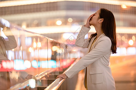 城市里捂脸伤心难过的女性图片