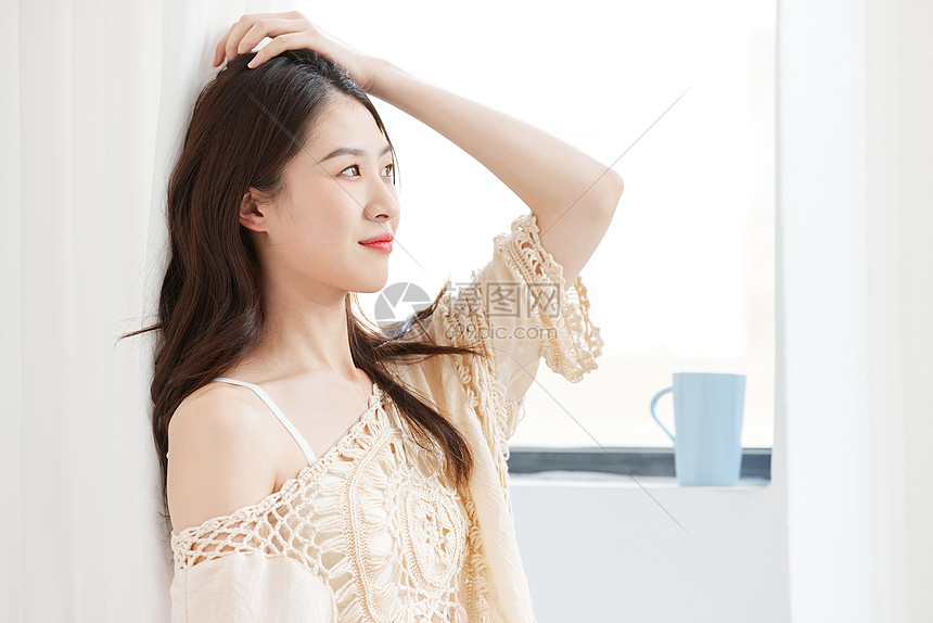 倚靠窗边的居家女性