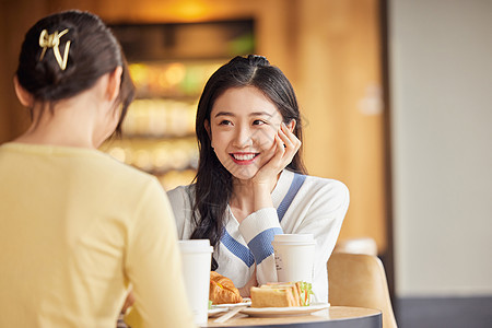 坐在店里聚会聊天的闺蜜二人图片