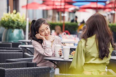 喝饮料美女年轻闺蜜们在室外餐桌前一起喝饮料聊天背景