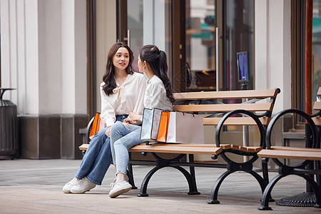 坐在户外聊天的年轻女性图片