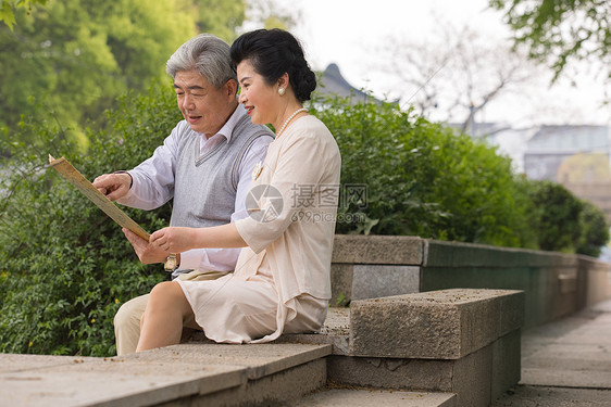 老年夫妻坐在石椅上看地图图片