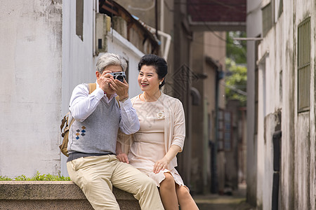 老年夫妻河畔小憩拍照图片