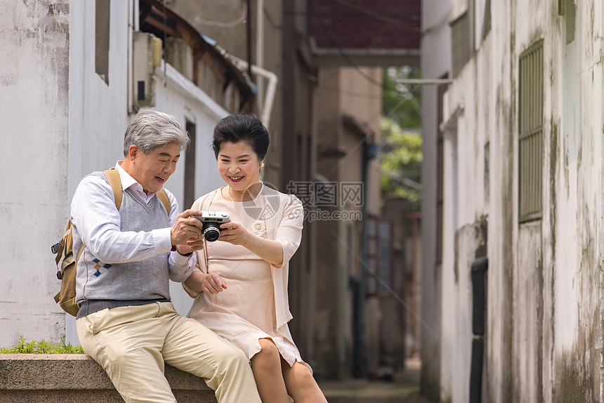 老年夫妻河畔小憩拍照图片