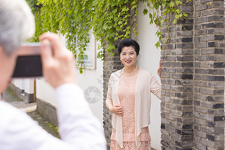 老年丈夫给妻子拍照高清图片