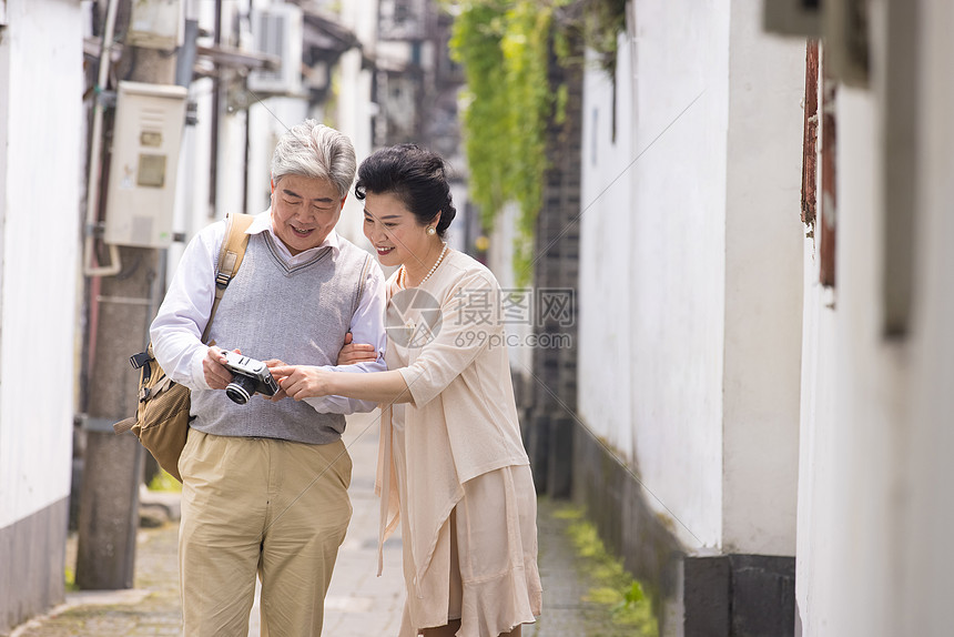 老年夫妻古镇巷子游玩拍照图片