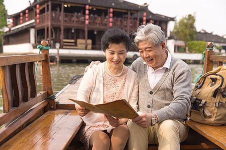 老年恩爱夫妻游船上看地图图片