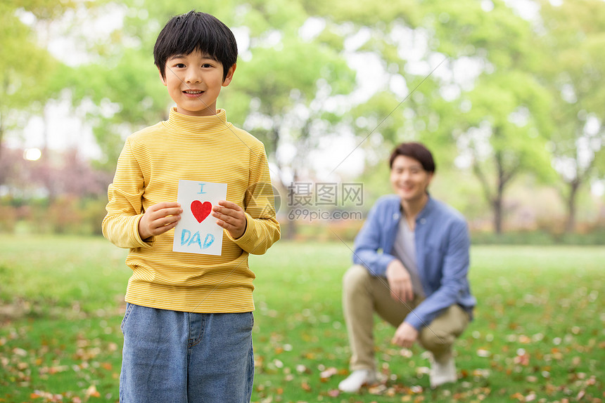 儿子拿爱心卡片送给爸爸图片