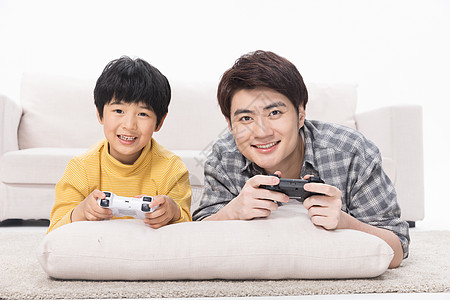 儿童娱乐父子居家地毯上玩电子游戏背景