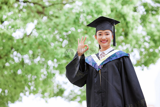 带着学位帽的女生手举毕业证书庆祝毕业ok手势图片