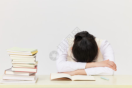 疲惫的学生趴在课桌前休息图片