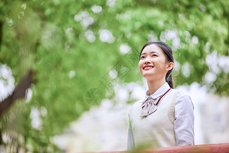 高中生学习户外校服女生抬头看背景