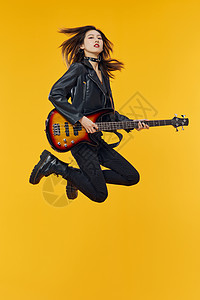 弹吉他的摇滚女孩跳跃动作高清图片