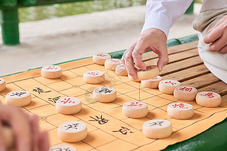 父子公园湖边下象棋手部特写背景图片