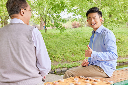 老年父子公园湖边下象棋图片