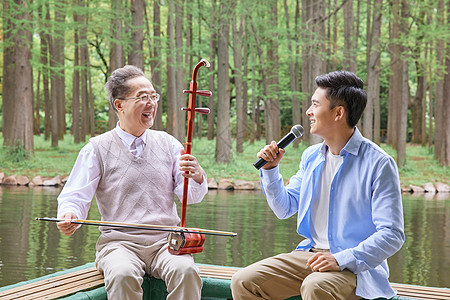 中年父子公园湖边拉二胡唱歌图片
