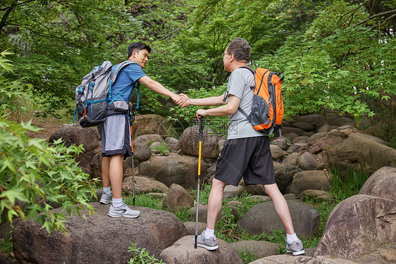 中年父子拿登山仗徒步郊游图片