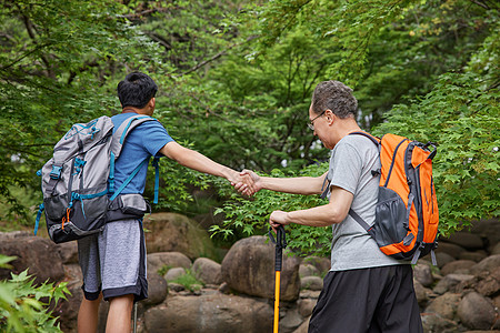 中年父子拿登山仗徒步郊游图片