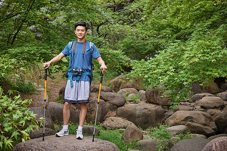 青年男性拿登山杖徒步图片