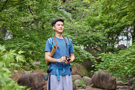 户外登山青年男性户外徒步拿相机眺望背景