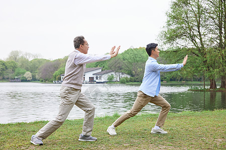 老年娱乐中年父子公园湖边打太极拳背景