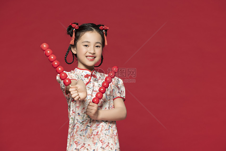 双手拿着冰糖葫芦的可爱小女孩